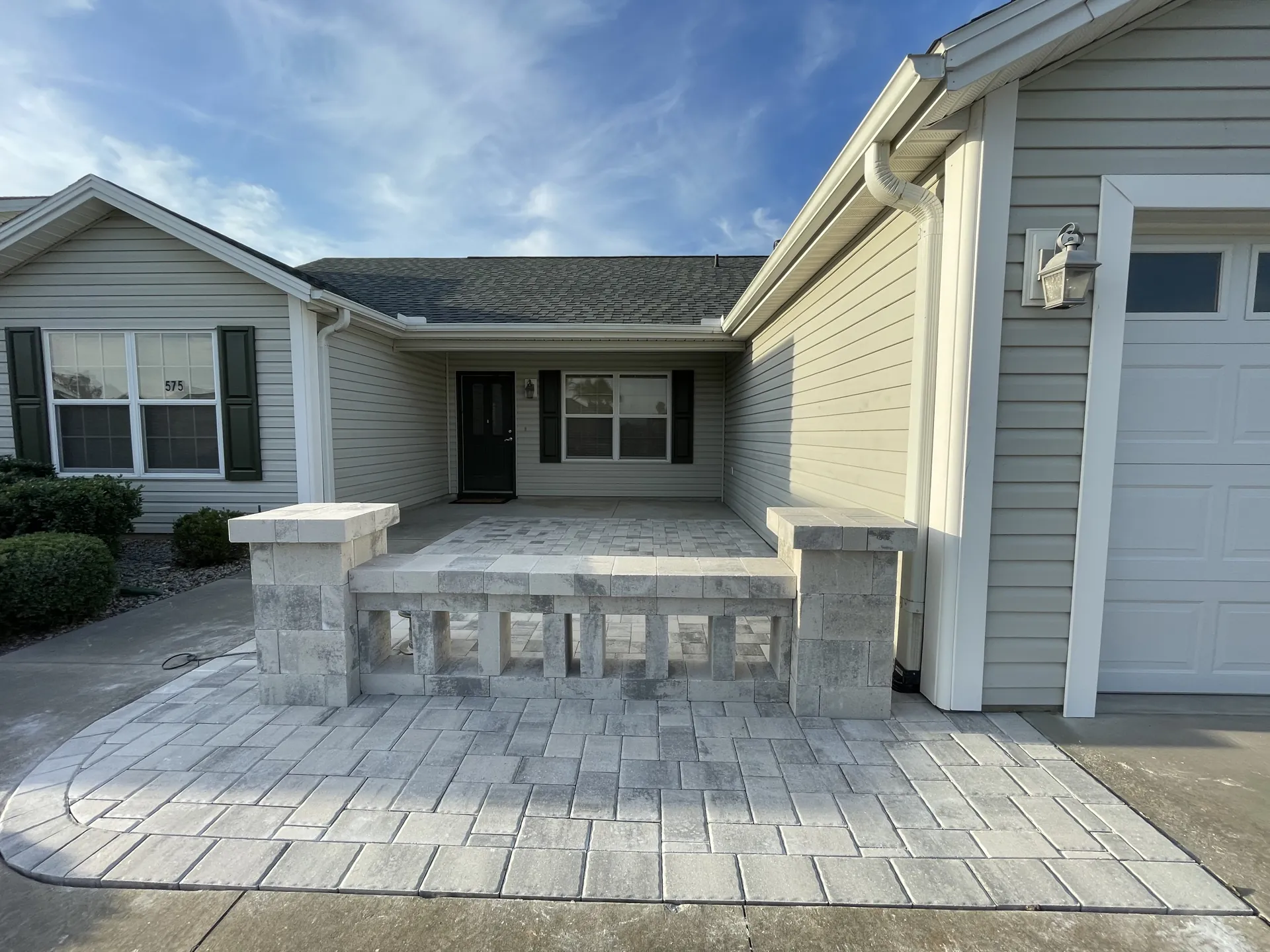 Paver front entry with stone wall and pillars